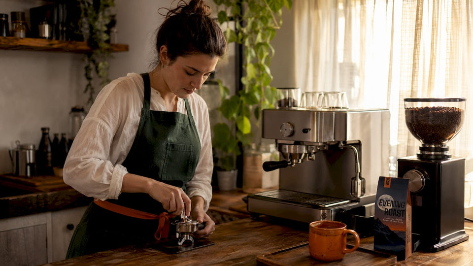 Woman tamping espresso grounds at home kitchen counter