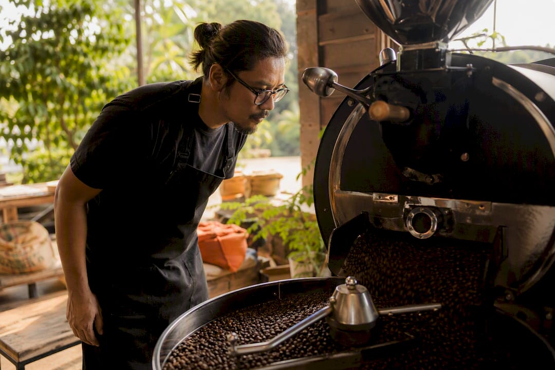 Coffee roaster inspecting small batch beans