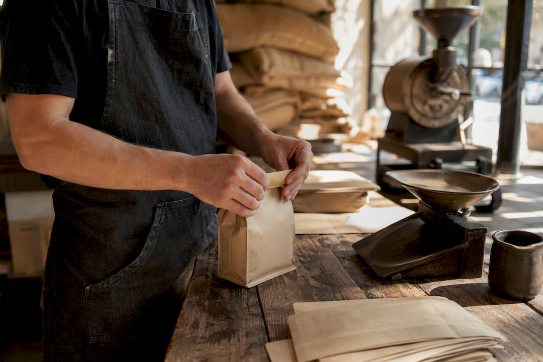 Hands sealing coffee bags in roastery