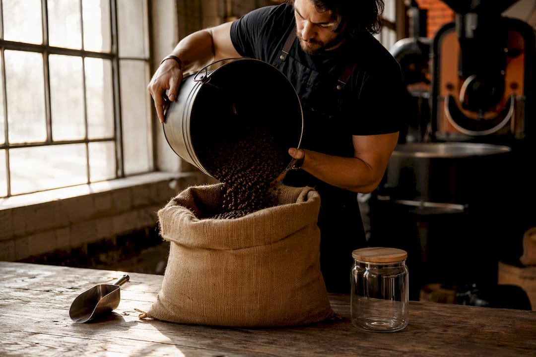 Hands weighing coffee beans for inventory