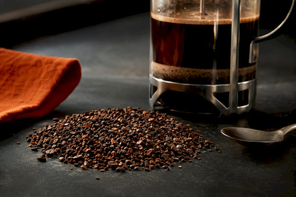 Coarse grounds beside a French press