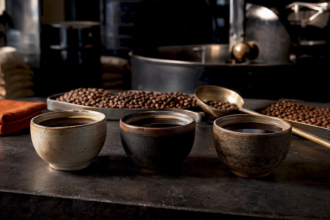 Three coffees on a roastery packing bench