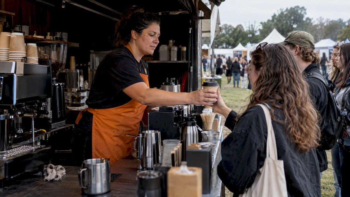 Barista serving coffee at a festival booth