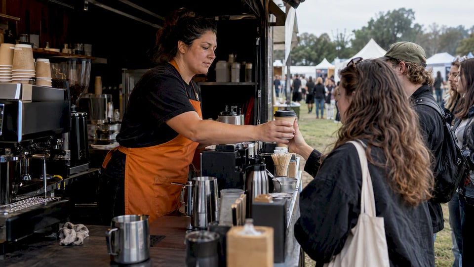 Barista serving coffee at a festival booth